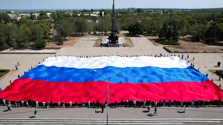 Eine russische Flagge wird vor dem Denkmal für die Befreier in der von Russland annektierten Stadt Luhansk ausgebreitet.