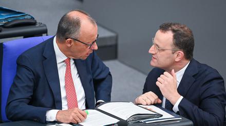 Bundeskanzler Friedrich Merz (links) unterhält sich mit Jens Spahn, dem Vorsitzenden der Unionsfraktion, im Bundestag. 