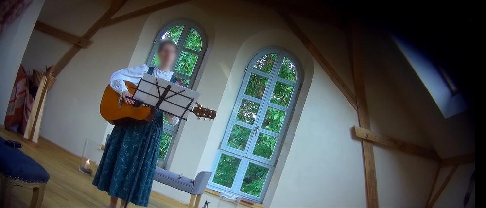 Die rechtsextreme Sängerin Friederike Jung bei einem Konzert, verpixelt auf einem verdeckt aufgenommenen Foto.