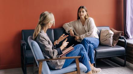 Eine Psychotherapeutin berät und unterstützt eine junge Patientin.