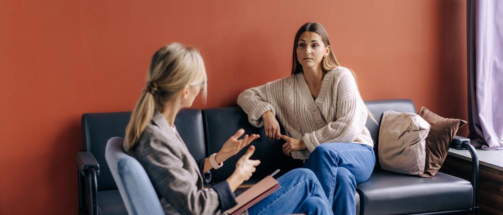 Eine Psychotherapeutin berät und unterstützt eine junge Patientin.