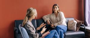 Eine Psychotherapeutin berät und unterstützt eine junge Patientin.
