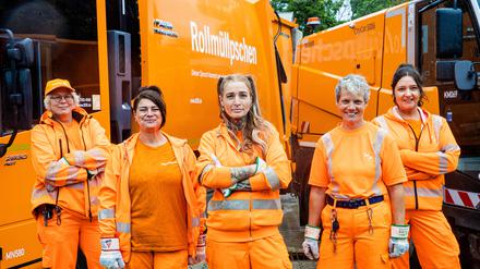 Frauen bei der Müllabfuhr vor einem Mülllaster.