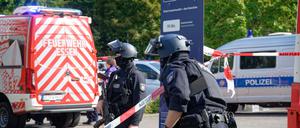 Polizisten stehen an einem Berufskolleg in Essen an einer Absperrung.