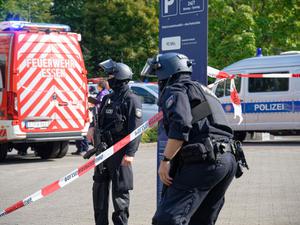 Polizisten stehen an einem Berufskolleg in Essen an einer Absperrung.