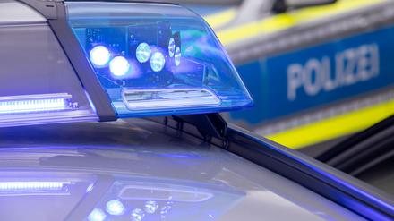 Ein Blaulicht leuchtet auf dem Dach eines Polizeifahrzeugs.