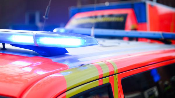 Blaulichter leuchten an einer Einsatzstelle auf einem Notarzt Fahrzeug und einem Rettungswagen.
