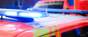 Blaulichter leuchten an einer Einsatzstelle auf einem Notarztfahrzeug und einem Rettungswagen.