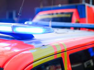 Blaulichter leuchten an einer Einsatzstelle auf einem Notarztfahrzeug und einem Rettungswagen.