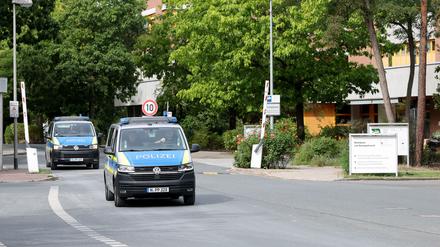 Zwei Fahrzeuge der Polizei verlassen das Gelände von dem Klinikum am Europakanal. 