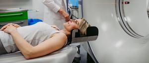 Eine Ärztin bereitet eine Frau für die Untersuchung im Computertomografen vor. (Symbolbild)