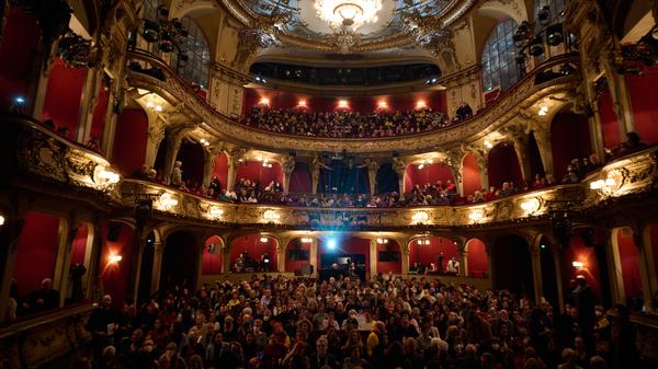 Menschen sitzen im Berliner Ensemble bei der Solidaritätsveranstaltung „Frau Leben Freiheit“. Im Berliner Ensemble lesen Schauspielerinnen Texte aus und über den Iran aus verschiedenen Epochen und solidarisieren sich so mit den Protestierenden im Iran. +++ dpa-Bildfunk +++