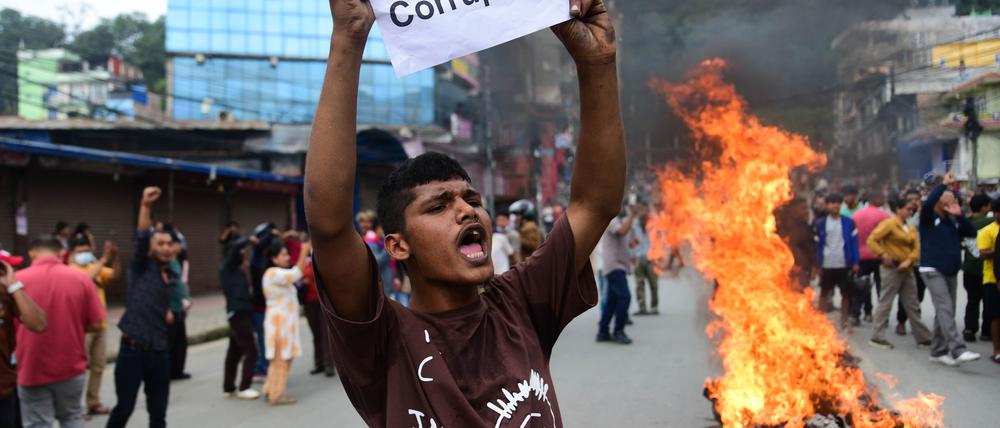 Ein Demonstrant in Nepal hält ein Blatt mit der Forderung nach einem Ende der Korruption hoch.