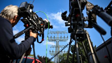 Kamerateams haben sich vor dem beschädigten Strommast im Königsheideweg aufgebaut. Nach stundenlangem Stromausfall in Berlin sind die ersten Haushalte wieder versorgt. 