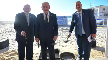Auf diesem von GPO zur Verfügung gestellten Bild ist der israelische Ministerpräsident Benjamin Netanjahu (M) bei der Grundsteinlegung für eine Promenade südlich von Tel Aviv zu sehen. Die Strandpromenade ist nach dem US-Präsidenten Trump benannt. 