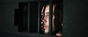 Ein junger Mann blickt aus einer Gefängnistür. Sie gelten als kalt, manipulierend, gefährlich. Doch sind Jugendliche mit psychopathischen Zügen wirklich verloren?