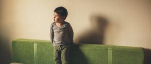 Ein Kind spielt allein auf einem Bett (Symbolbild).