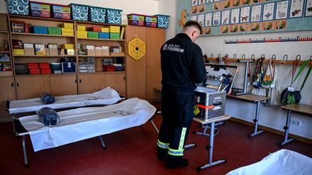 Ein Feuerwehrmann bereitet Sauerstoffversorgung für Bedürftige in einer Anlaufstelle in Altglienicke im Bezirk Treptow-Köpenick vor. 