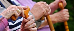 Senioren sitzen in Leichlingen mit Gehstöcken auf einer Parkbank. (Symbolfoto)