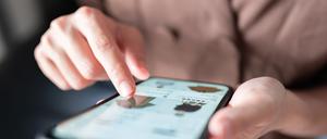 Eine Frau beim Online-Shopping für Modekleidung auf ihrem Smartphone.