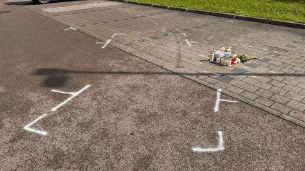Markierungen mit Sprühfarben und Trauerbekundungen sind auf einem Parkplatz zu sehen. Nach einem Streit auf einem Parkplatz soll ein 18-Jähriger einen 12 Jahre alten Jungen in Niedernhall (Hohenlohekreis) mit dem Auto verfolgt, angefahren und tödlich verletzt habe. 