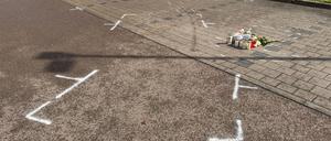 Markierungen mit Sprühfarben und Trauerbekundungen sind auf einem Parkplatz zu sehen. Nach einem Streit auf einem Parkplatz soll ein 18-Jähriger einen 12 Jahre alten Jungen in Niedernhall (Hohenlohekreis) mit dem Auto verfolgt, angefahren und tödlich verletzt habe.