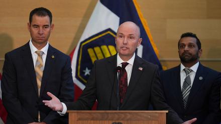 Der Gouverneur von Utah, Spencer Cox (M), spricht auf einer Pressekonferenz, während der Beauftragte des Ministeriums für öffentliche Sicherheit von Utah, Beau Mason (l) und der FBI-Direktor Kash Patel zuhören.