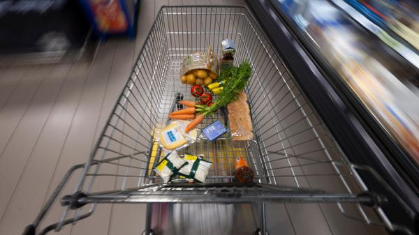 Ein Einkaufswagen mit Lebensmitteln in einem Supermarkt.