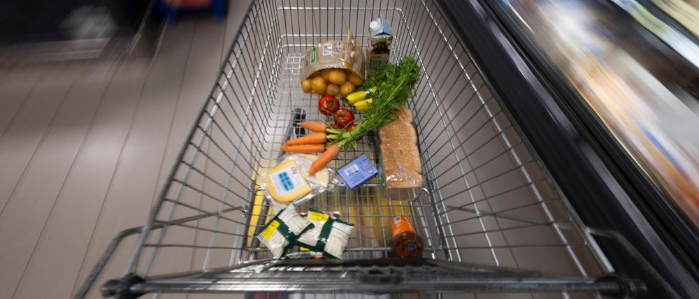 Ein Einkaufswagen mit Lebensmitteln in einem Supermarkt.