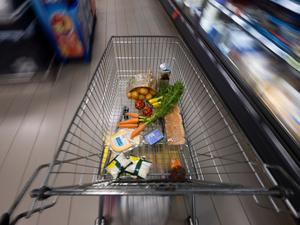 Ein Einkaufswagen mit Lebensmitteln in einem Supermarkt. 