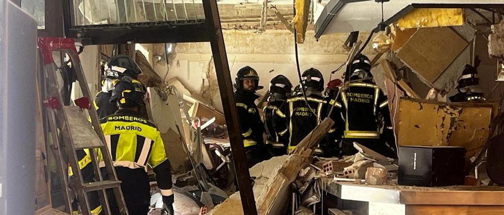 Feuerwehrleute stehen in einem Café nach dem es dort eine Explosion gegeben hat,