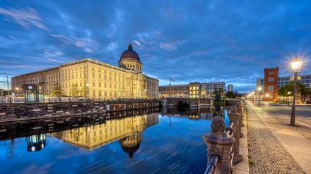 The rebuilt Berlin City Palace reflected in a small canal before sunrise