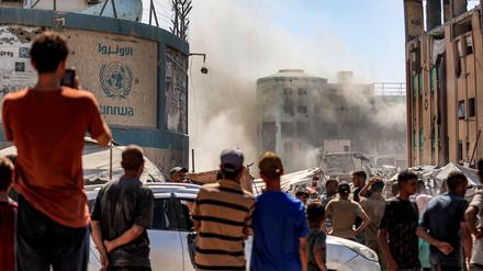 Palästinenser beobachten eine Explosion in einem Gebäude der Islamischen Universität in Gaza.