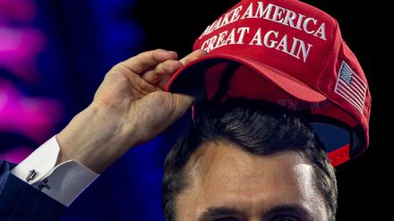 Der vor kurzem getötet rechtsextreme US-Influencer Charlie Kirk beim Aufsetzen einer MAGA-Kappe beim AmericaFest 2024.