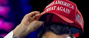 Der vor kurzem getötet rechtskonservativen US-Influencer Charlie Kirk beim Aufsetzen einer MAGA-Kappe beim AmericaFest 2024.
