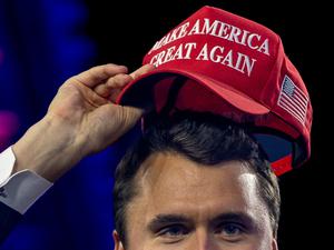 Der vor kurzem getötet rechtsextreme US-Influencer Charlie Kirk beim Aufsetzen einer MAGA-Kappe beim AmericaFest 2024.