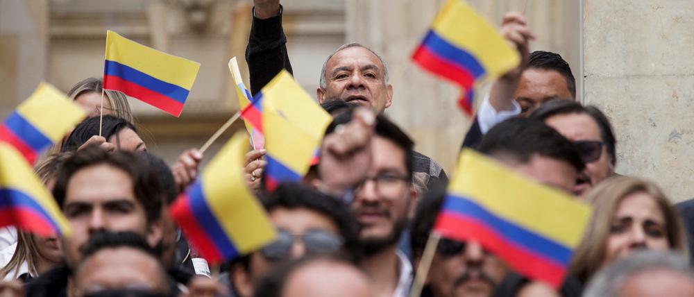 Menschen schwenken die kolumbianische Flagge.