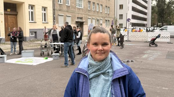 Eine Anwohnerin der Strausberger Straße, mit Auto und Kind. 