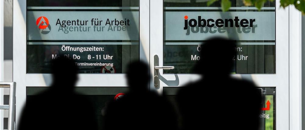 Menschen vor der Agentur für Arbeit und dem Jobcenter.