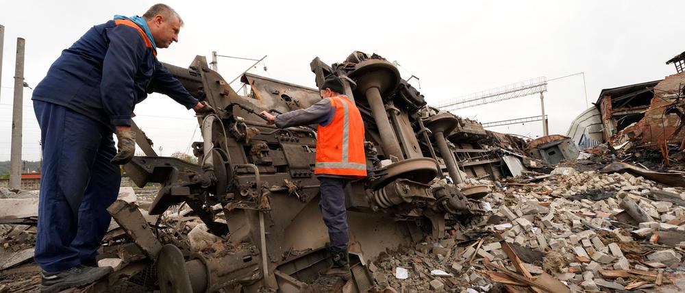 Eisenbahner räumen die Trümmer auf, nachdem ein Eisenbahndepot bei einem, mutmaßlich russischen, Raketenangriff zerstört wurde (Symbolbild).