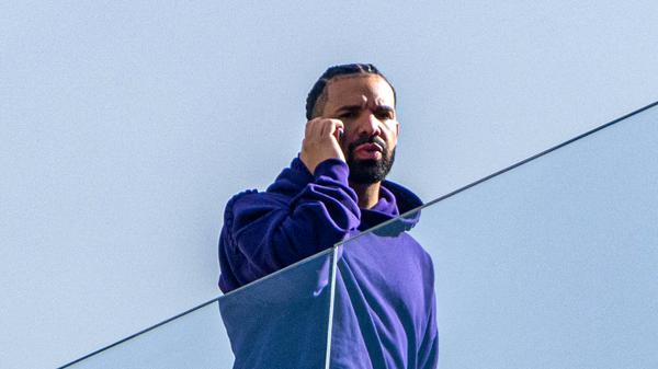 Rapper Drake telefoniert hinter einer Glasfassade. (Archivbild)