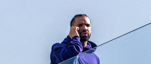 Rapper Drake telefoniert hinter einer Glasfassade. (Archivbild)
