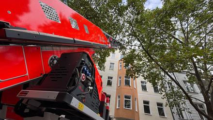 Nach einem Dachstuhlbrand in der Motzstraße ist ein Einsatzwagen noch zur Nachbearbeitung vor Ort. Auf dem gesamten Gehweg ist Löschschaum verteilt.