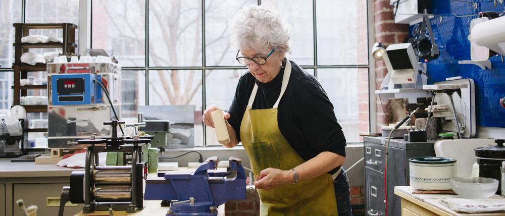 Seniorin in Werkstatt. Wer im Rentenalter weiterarbeitet, soll mit der sogenannten Aktivrente bis zu 2000 Euro im Monat steuerfrei verdienen können.