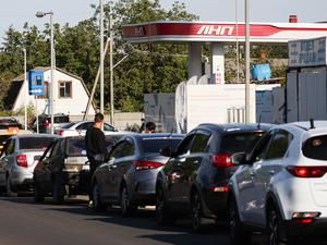Im von Russland Luhansk stehen am 10. September 2025 Autos vor einer Tankstelle an.