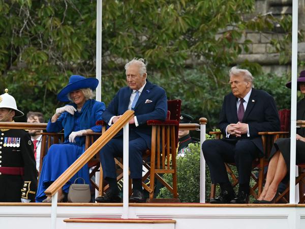 Britain's King Charles III (2L) and Britain's Queen Camilla (L) share a joke as they sit with US President Donald Trump (2R) and US First Lady Melania Trump (R) watching the Beating Retreat military ceremony on the East Lawn at Windsor Castle, in Windsor, on September 17, 2025, during the US president's second State Visit. US President Donald Trump arrived in Britain for an unprecedented second State Visit, with the UK government rolling out a royal red carpet welcome to win over the mercurial leader. (Photo by ANDREW CABALLERO-REYNOLDS / AFP)