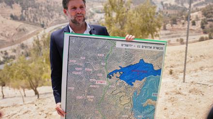 Der israelische Finanzminister Bezalel Smotrich hält während einer Pressekonferenz in der Nähe der Siedlung Maale Adumim im israelisch besetzten Westjordanland eine Karte, auf der das Siedlungsprojekt E1 dargestellt ist.