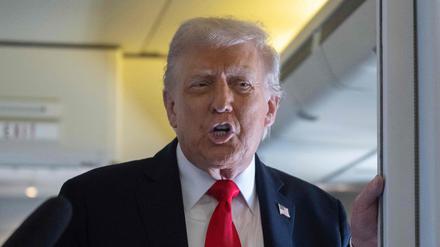 US-Präsident Donald Trump spricht an Bord der Air Force One während des Fluges nach Großbritannien mit Mitgliedern der Presse.