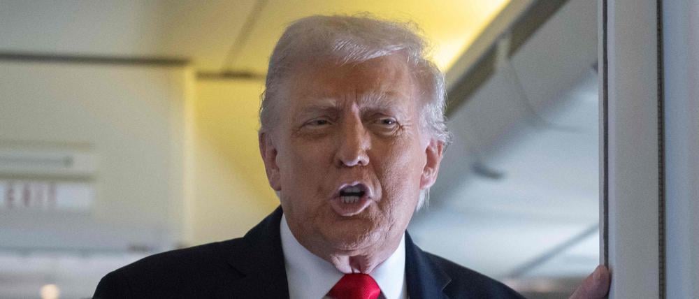 US-Präsident Donald Trump spricht an Bord der Air Force One während des Fluges nach Großbritannien mit Mitgliedern der Presse.