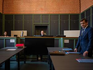Burkhard Niebisch (M), Vorsitzender Richter, sitzt vor Beginn der Verhandlung über die Räumungsklage gegen die AfD im Saal 100 am Landgericht II auf seinem Platz. Rechts steht Kay Gottschalk, stellvertretender Bundessprecher der AfD vor Gericht, links der Anwalt der Immobilienfirma Quercus Grund GmbH.